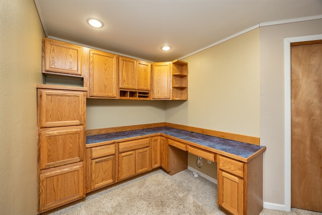 office featuring light colored carpet, built in desk, and ornamental molding