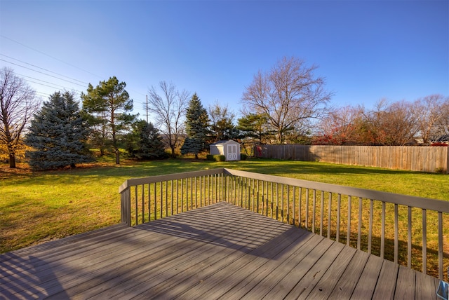 wooden deck featuring a lawn and a storage shed