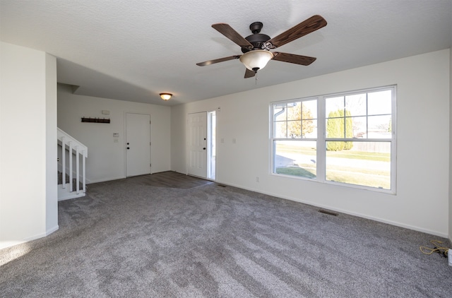 unfurnished living room featuring carpet flooring, ceiling fan, and a textured ceiling