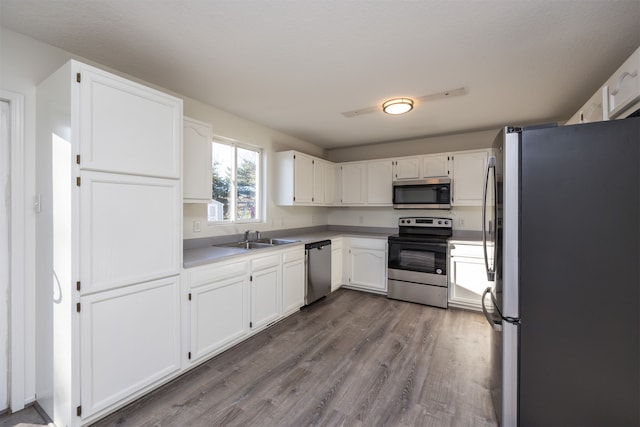 kitchen with white cabinets, wood-type flooring, sink, and appliances with stainless steel finishes