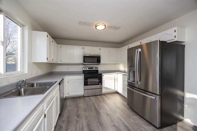 kitchen with sink, white cabinets, plenty of natural light, and appliances with stainless steel finishes