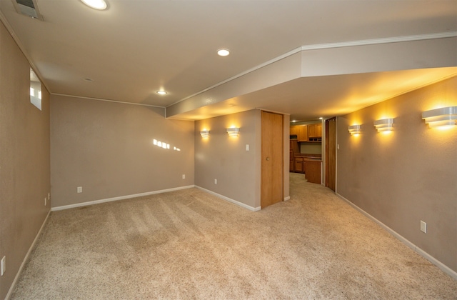 basement featuring light carpet and ornamental molding