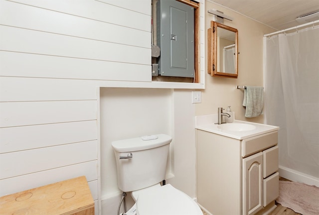 bathroom featuring electric panel, baseboards, a shower with shower curtain, toilet, and vanity