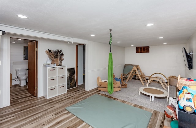 game room featuring hardwood / wood-style floors and a textured ceiling