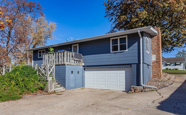 view of front facade with stairway, concrete driveway, a chimney, and an attached garage