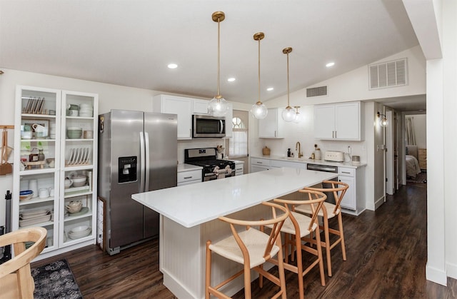 kitchen featuring vaulted ceiling, visible vents, stainless steel appliances, and light countertops