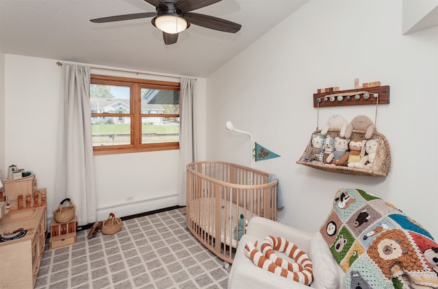 bedroom with ceiling fan, lofted ceiling, a baseboard radiator, and a nursery area