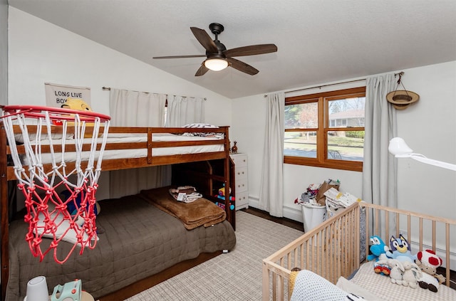 bedroom with lofted ceiling, ceiling fan, wood finished floors, a textured ceiling, and a baseboard heating unit