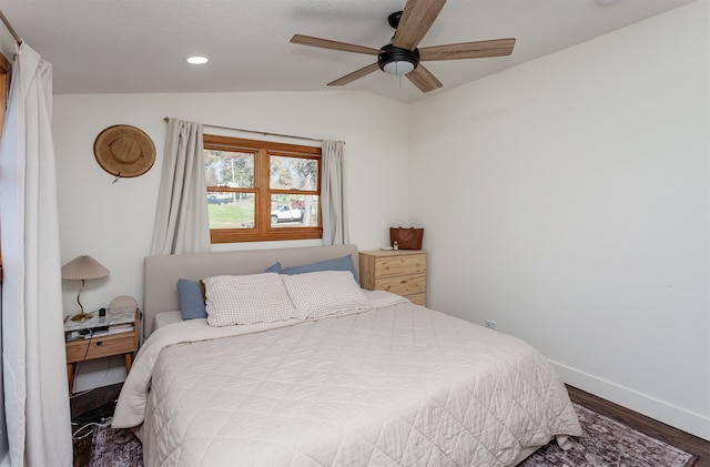 bedroom with ceiling fan, dark hardwood / wood-style floors, and lofted ceiling