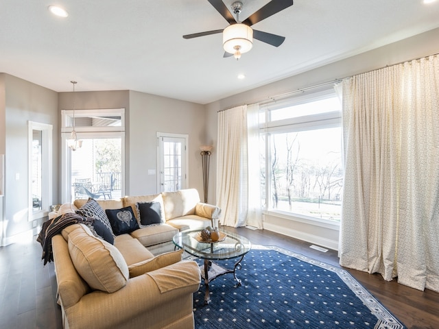 living room featuring plenty of natural light, dark hardwood / wood-style floors, and ceiling fan with notable chandelier