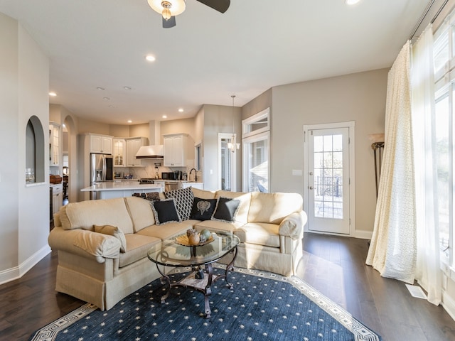 living room featuring ceiling fan and dark hardwood / wood-style flooring