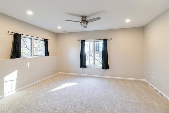 empty room featuring ceiling fan, a healthy amount of sunlight, and light colored carpet