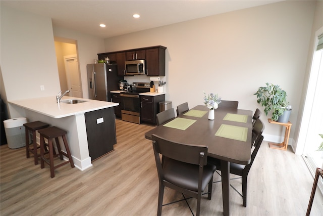 dining area with light wood-type flooring and sink