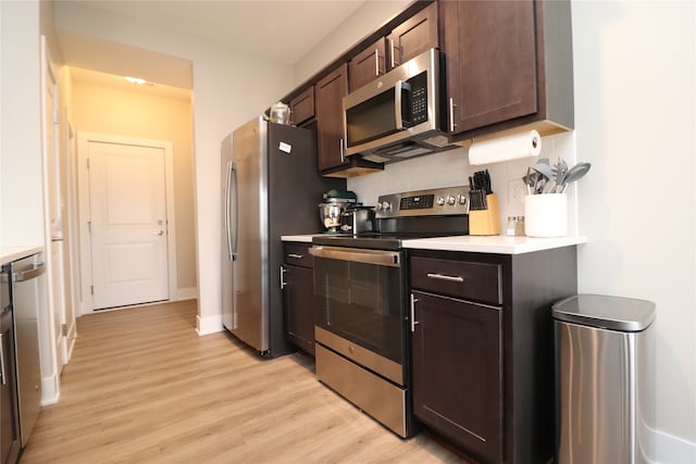 kitchen featuring light hardwood / wood-style floors, dark brown cabinetry, appliances with stainless steel finishes, and tasteful backsplash