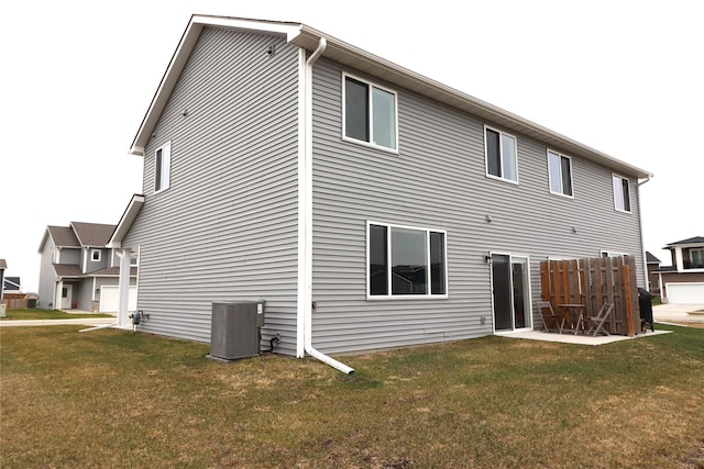 back of house featuring central air condition unit and a yard