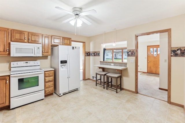 kitchen featuring white appliances, decorative light fixtures, and ceiling fan