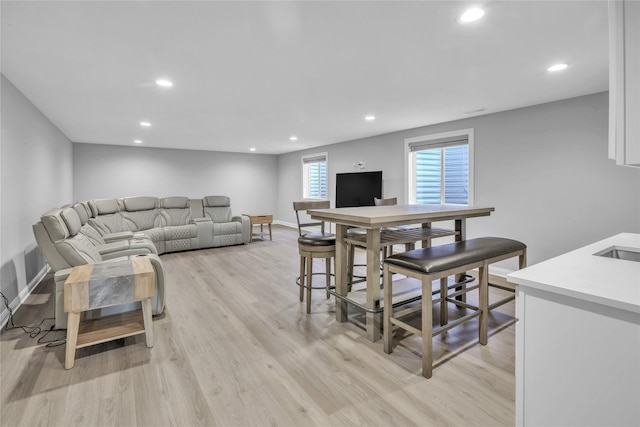 living room with baseboards, light wood-type flooring, and recessed lighting