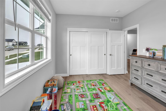 game room with light wood-style floors and visible vents