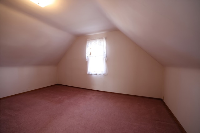 additional living space featuring carpet flooring and lofted ceiling