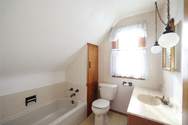 bathroom with a wealth of natural light, a washtub, vanity, and lofted ceiling