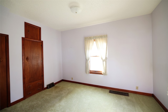 unfurnished bedroom with carpet and a textured ceiling