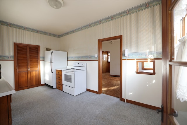 kitchen with a wealth of natural light, light colored carpet, and white appliances