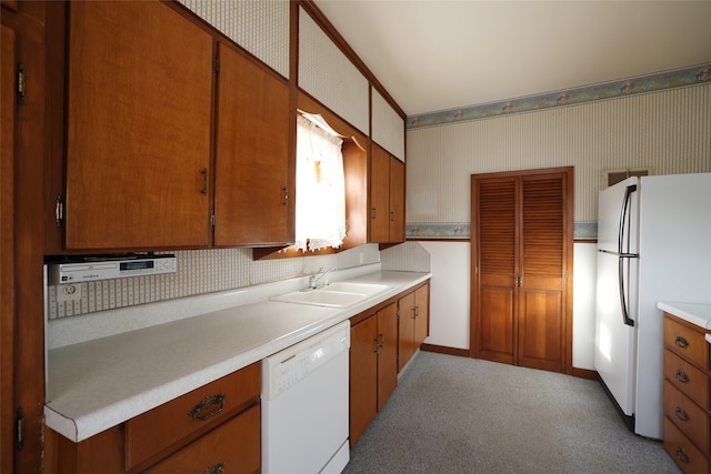 kitchen featuring white appliances, light colored carpet, and sink