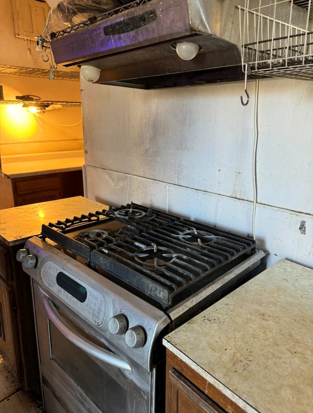 kitchen with white gas range and exhaust hood