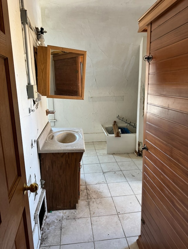 bathroom featuring tile patterned flooring, vanity, and a bathing tub