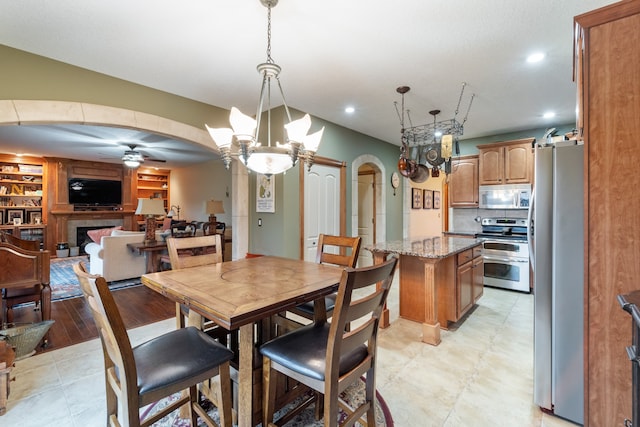 dining area featuring ceiling fan with notable chandelier and light hardwood / wood-style floors