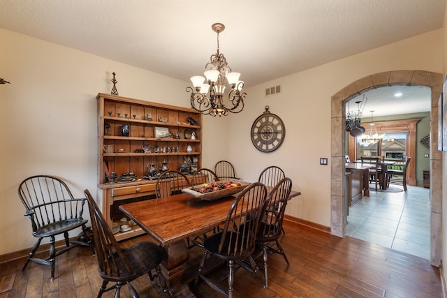 dining area featuring dark hardwood / wood-style floors and an inviting chandelier