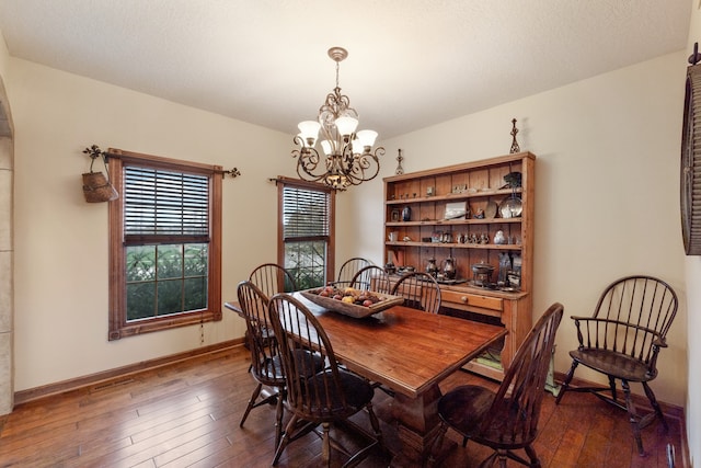 dining space with a notable chandelier and dark hardwood / wood-style floors