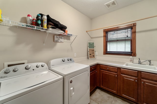 laundry area with sink, cabinets, separate washer and dryer, a textured ceiling, and light tile patterned floors