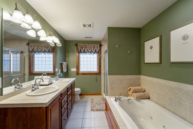 full bathroom with tile patterned flooring, vanity, a textured ceiling, and a healthy amount of sunlight