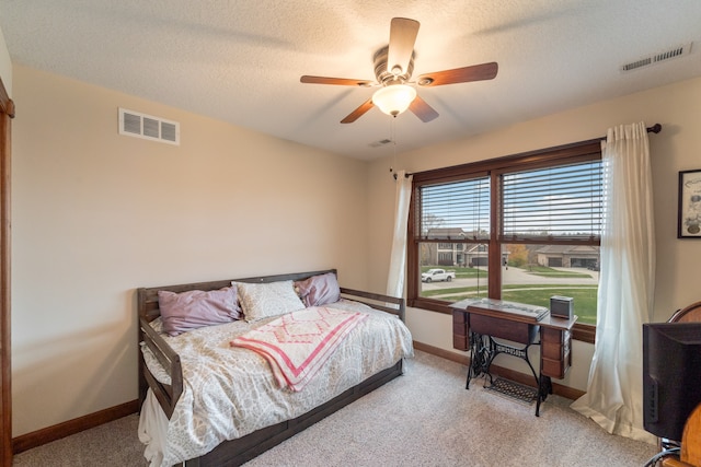 carpeted bedroom featuring a textured ceiling and ceiling fan