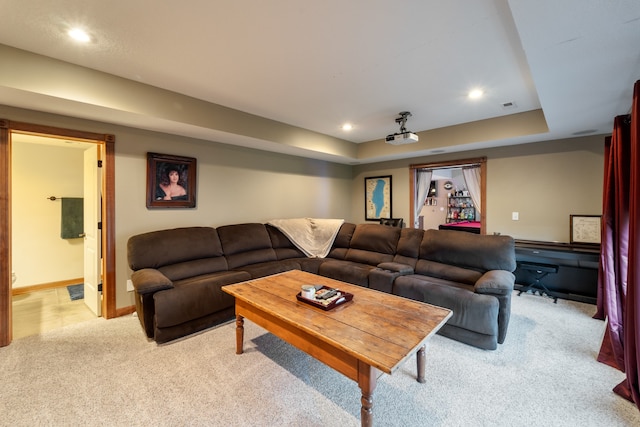 carpeted living room featuring a tray ceiling