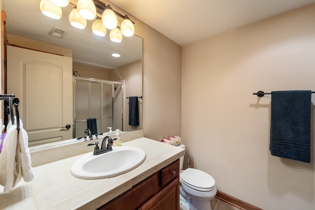 bathroom featuring tile patterned floors, vanity, toilet, and an enclosed shower