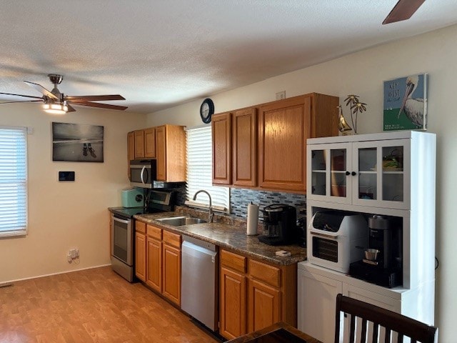 kitchen featuring a wealth of natural light, sink, stainless steel appliances, and light wood-type flooring