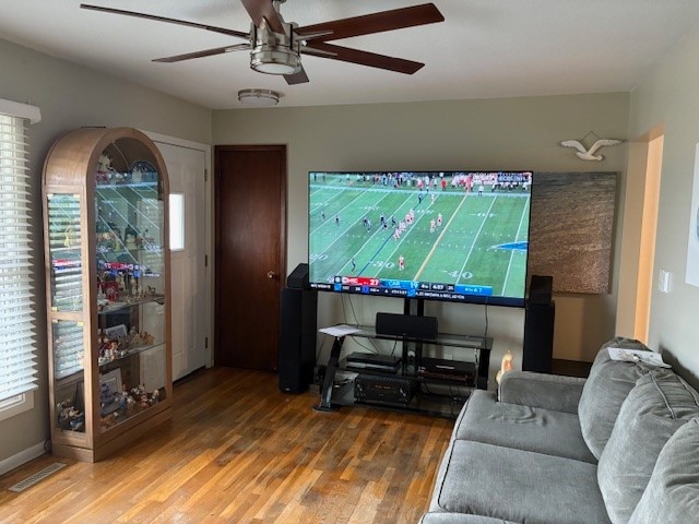 living room featuring ceiling fan, plenty of natural light, and wood-type flooring