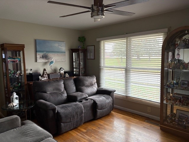 living room with light wood-type flooring and ceiling fan