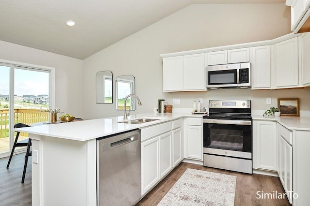 kitchen with stainless steel appliances, white cabinets, and kitchen peninsula