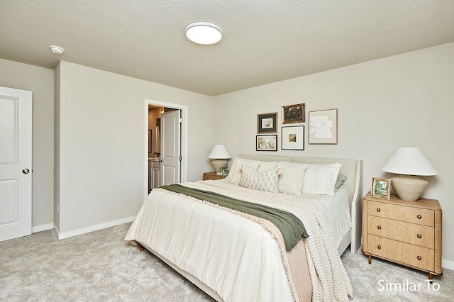 bedroom featuring light carpet, connected bathroom, and a textured ceiling