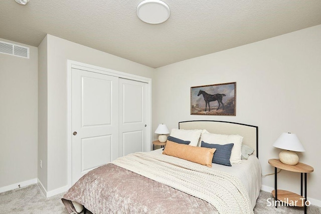 bedroom with light colored carpet, a closet, and a textured ceiling