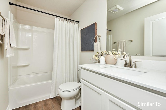 full bathroom featuring vanity, hardwood / wood-style floors, shower / bath combination with curtain, and toilet