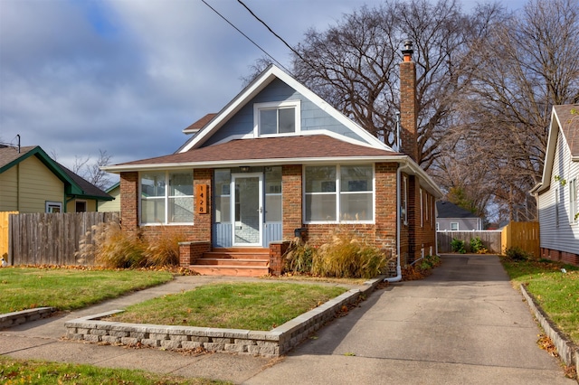 bungalow-style home with a front yard