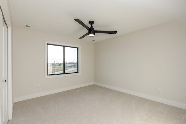 unfurnished bedroom featuring a closet, light colored carpet, and ceiling fan