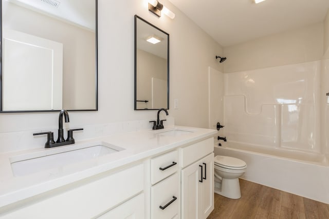 full bathroom featuring hardwood / wood-style flooring, vanity, toilet, and washtub / shower combination