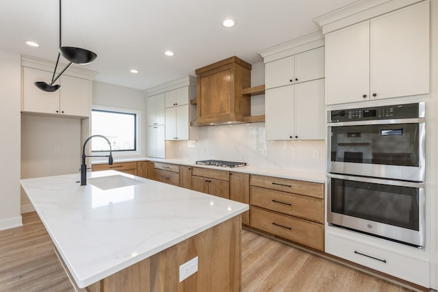 kitchen with white cabinetry, sink, a kitchen island with sink, and stainless steel appliances