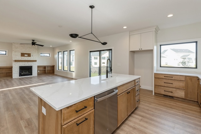 kitchen featuring dishwasher, sink, hanging light fixtures, a kitchen island with sink, and white cabinets