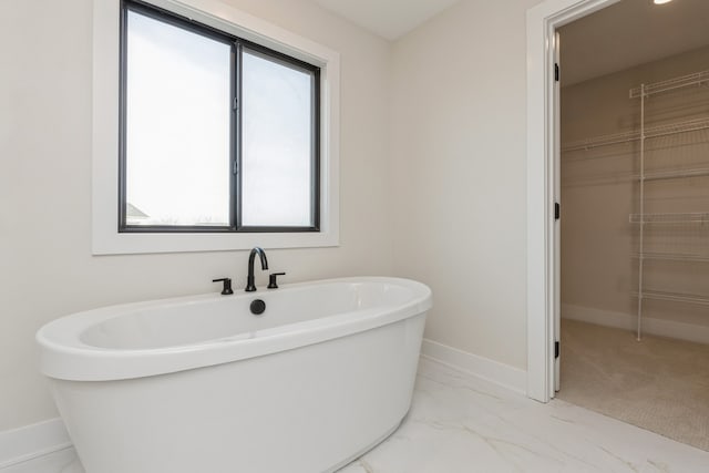 bathroom featuring plenty of natural light and a tub